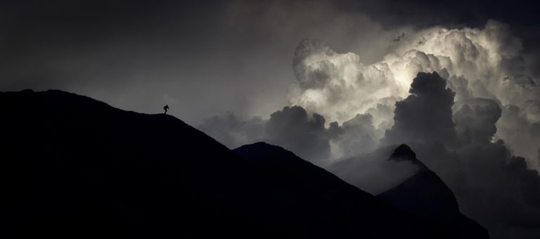 Photographie d&rsquo;Alexandre Deschaumes &ndash; Col d&rsquo;Anterne, massif du Haut-Giffre : silhouette d&rsquo;un coureur sur la cr&ecirc;te devant un cumulonimbus orageux, ambiance mystique et dramatique