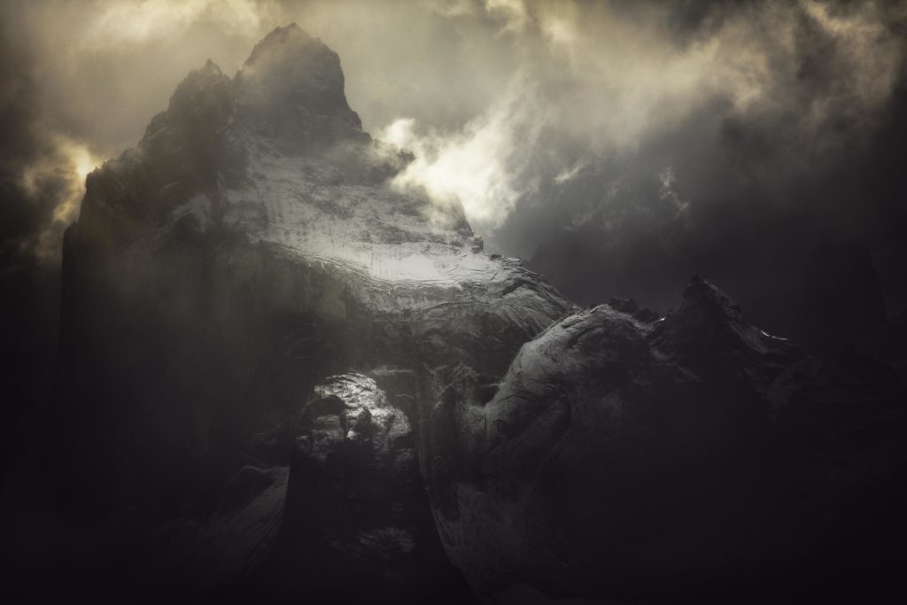 Photographie d&rsquo;Alexandre Deschaumes &ndash; Cuernos del Paine, parc Torres del Paine au Chili. Ambiance mystique et puissante, montagnes sombres &eacute;clair&eacute;es par la lumi&egrave;re dramatique.