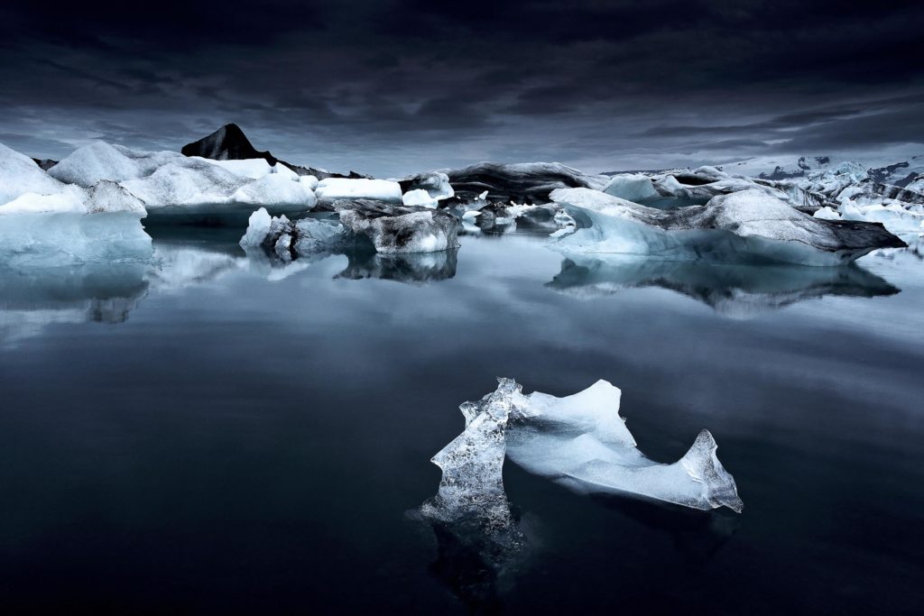 Icebergs bleus dans la lagune glaciaire de J&ouml;kuls&aacute;rl&oacute;n en Islande, photographie nocturne en juin sous une lumi&egrave;re sombre et myst&eacute;rieuse